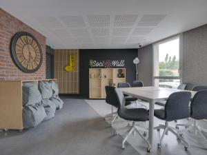 エクス・アン・プロヴァンスにあるStudent Factory Aix-en-Provence Pont de l'Arcのテーブル、椅子、時計が備わる客室です。