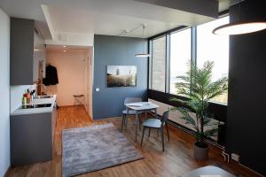 a kitchen and dining room with a table and a plant at First Hotel The Studio in Stockholm