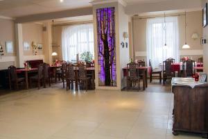 Hotel Karkonosze في كاميين غورا: غرفة طعام مع طاولات ونافذة زجاجية ملطخة