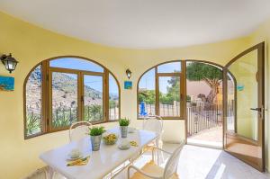 a dining room with a table and chairs and windows at Villas Guzman - Antonio in Calpe