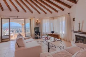 a living room with white furniture and a fireplace at Villas Guzman - Arcadien in Calpe