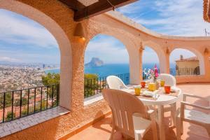 a table and chairs on a balcony with a view of the ocean at Villas Guzman - Arcadien in Calpe