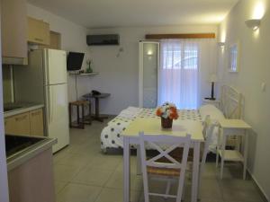 a kitchen and dining room with a table and a refrigerator at Muses Studios Sami in Sami