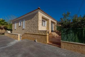 Casa de ladrillo con ventanas blancas y entrada en Villas Guzman - Chirla en Calpe