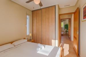 1 dormitorio con 1 cama blanca y ventilador de techo en Villas Guzman - Chirla, en Calpe