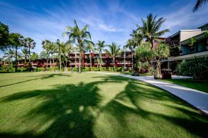 een schaduw van een palmboom op een golfbaan bij Ramada Resort by Wyndham Khao Lak in Khao Lak