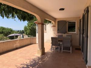 eine Terrasse mit einem Tisch, Stühlen und einem Sonnenschirm in der Unterkunft Cozy Villa in Caunes Minervois with Swimming Pool in Caunes-Minervois