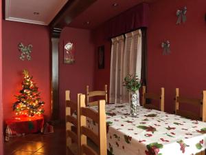 un comedor con una mesa con un árbol de Navidad en Casa de Aldea el Pontón, en Cue