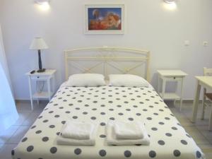 een slaapkamer met een bed met 2 kussens erop bij Muses Studios Sami in Sami