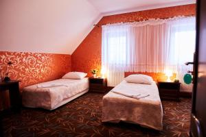 a hotel room with two beds and a window at Zielony Zakątek in Ostrołęka
