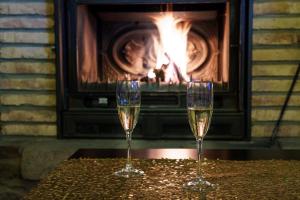 zwei Gläser Champagner auf einem Tisch vor einem Kamin in der Unterkunft Posada Los Cantaros in Pizarra