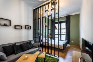 uma sala de estar com um sofá e uma mesa em BpR Emerald City Apartment em Budapeste