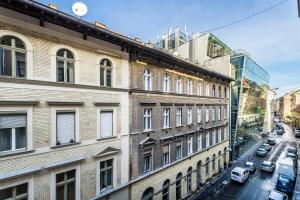 a view of a building with cars parked on a street at BpR Emerald City Apartment in Budapest