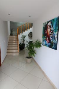 a hallway with a staircase with a painting on the wall at Lali's House in Tarrafal