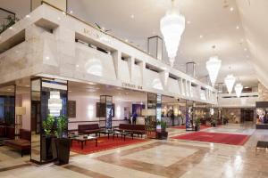 a lobby of a shopping mall with tables and chairs at Aerostar Hotel in Moscow