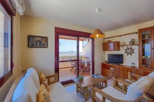 sala de estar con sofá, mesa y TV en Villas Guzman - Apartamento Coral Beach, en Calpe