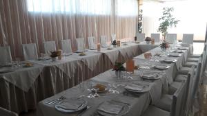 a group of long tables with white table cloths and chairs at Hotel Elio in Marigliano