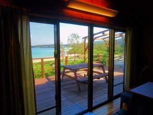 a view of a porch with a picnic table on a deck at Private Beach House in Motobu