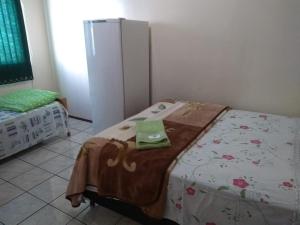 a room with a bed and a refrigerator at Hotel Do Oeste in Palmitos