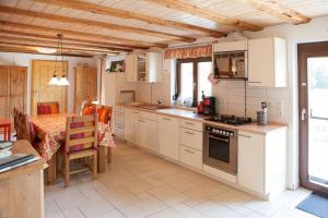 a kitchen with white cabinets and a table and a dining room at Gerberlaube in Meßkirch