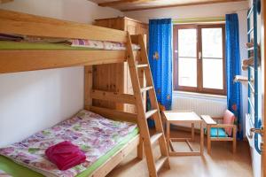 a bedroom with two bunk beds and a table and a chair at Gerberlaube in Meßkirch