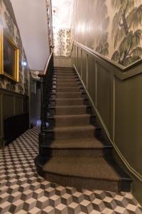 uma escadaria num edifício com piso em xadrez em Georgian House Hotel em Londres