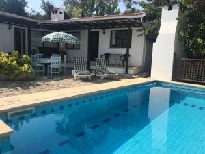 a swimming pool in front of a house at Hidden Cottage in Kyrenia