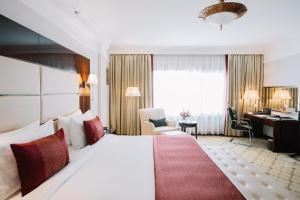 アディスアベバにあるGolden Tulip Addis Ababaの大きなベッドと机があるホテルの部屋 +37枚の写真