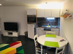 uma cozinha com uma mesa branca e uma cozinha com uma televisão em Ruhige Wohnung in zentraler Lage Tübingens em Tübingen