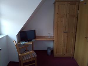 um quarto com uma secretária, um computador e uma escada em Landhotel Keils Gut em Wilsdruff