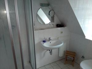 a white bathroom with a sink and a shower at Landhotel Keils Gut in Wilsdruff