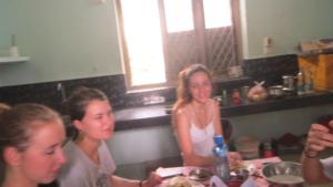 a group of women sitting at a table in a kitchen at Countryside inn in Tiruvankod