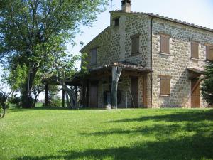 ein altes Backsteinhaus auf einem Grasfeld in der Unterkunft Villa Arzilla in Amandola