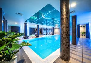uma piscina num edifício com plantas em Wellton Riverside SPA Hotel em Riga