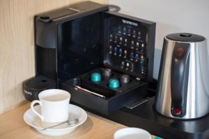 a microwave sitting on a counter with a cup of coffee at Kamienica nr 6 in Aleksandrów Łódzki