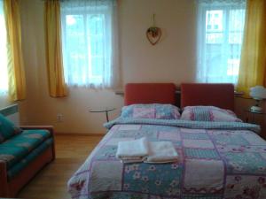 a bedroom with a bed and a couch and windows at Jiřetínská chaloupka in Jiřetín pod Jedlovou