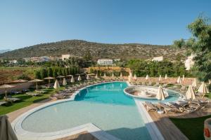 uma grande piscina com guarda-sóis e cadeiras em Cactus Royal Spa & Resort em Stalida