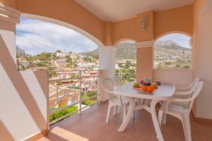 balcón con mesa, sillas y vistas en Villas Guzman - Dora, en Calpe
