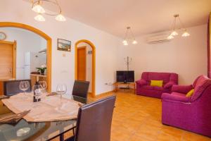 salon ze stołem i fioletowymi meblami w obiekcie Villas Guzman - Dora w mieście Calpe
