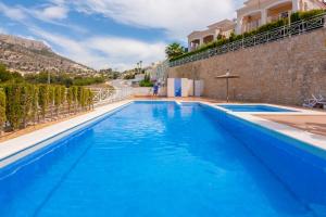 duży niebieski basen obok budynku w obiekcie Villas Guzman - Dora w mieście Calpe