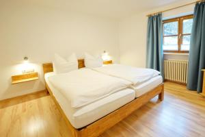 オフターシュヴァングにあるHaus Steinのベッドルーム1室(白いシーツ付きのベッド1台、窓付)