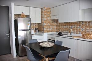 a kitchen with a black table and a refrigerator at Departamento de lujo Antofagasta in Antofagasta
