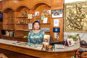 a woman standing behind a counter in a room at Andaman Sea Guesthouse Patong in Patong Beach