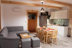 a kitchen and a living room with a couch and a table at Domki w Beskidach in Zarzecze