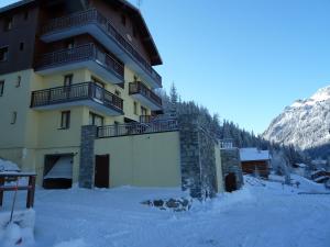 a building in the snow with a garage at Chalet Jonquille in Valfréjus
