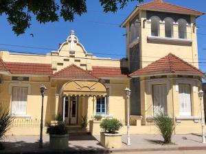 a large yellow building with a clock tower at Hotel El Mirador in Chascomús