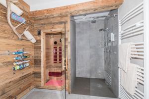 a shower in a bathroom with wooden walls at Apartchalet Almliebe in Maria Alm am Steinernen Meer