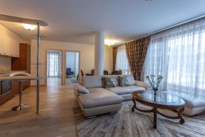 Violetos Lux Apartamentai في دروسكينينكاي: غرفة معيشة مع أريكة وطاولة