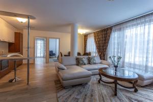 a living room with a couch and a table at Violetos Lux Apartamentai in Druskininkai
