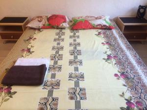 a bed with a blanket and pillows on it at Apartment Vosstania Square in Gomel